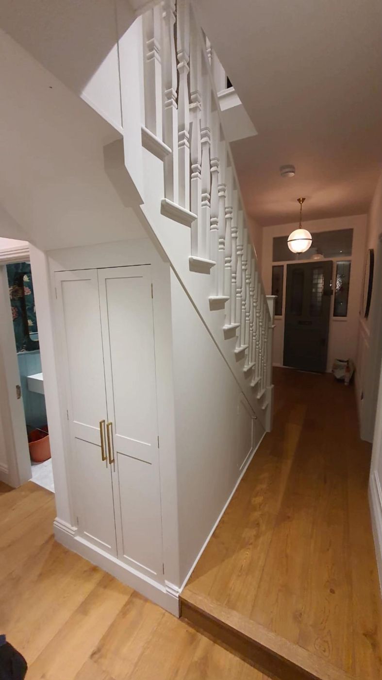 Hallway with understairs storage and oak floor